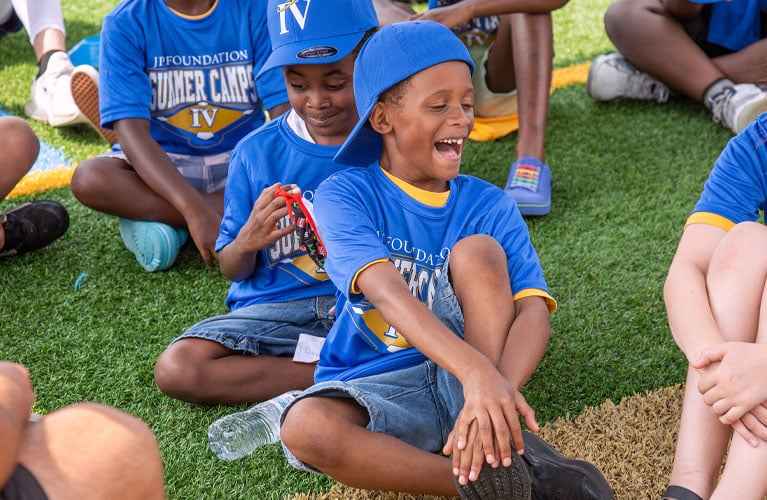 Laughing child participating in a JP4 Foundation baseball camp