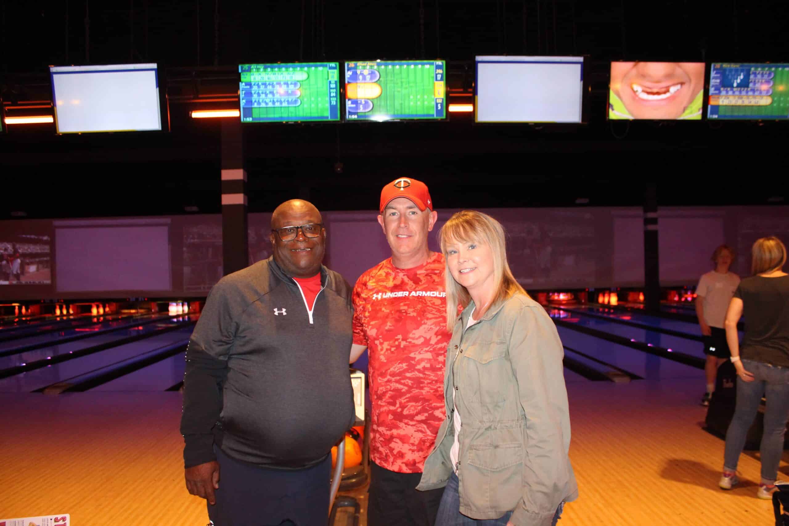 Three people at a bowling alley